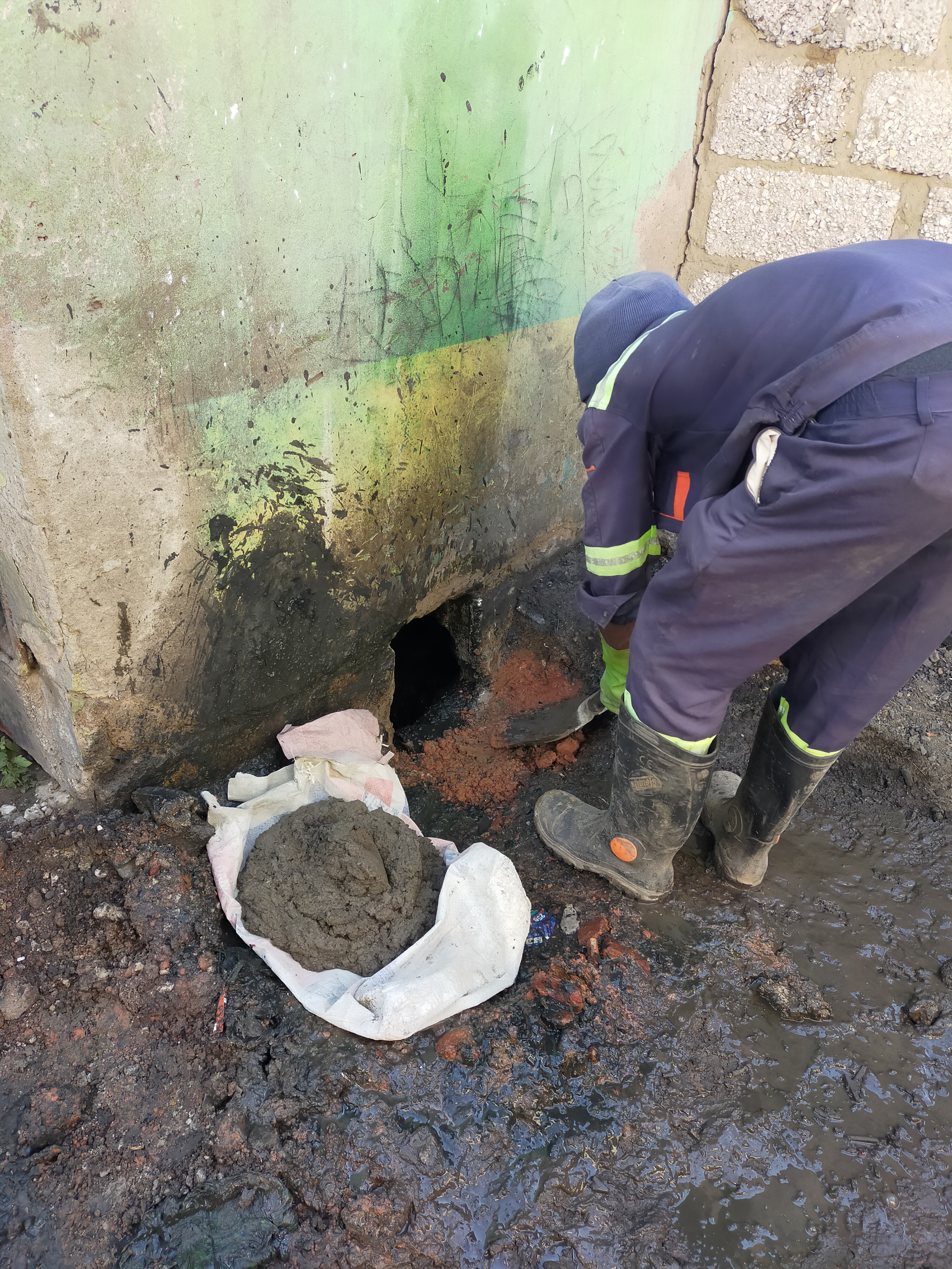A pit emptying worker wearing PPE during pit latrine emptying. Shotaro Goto.