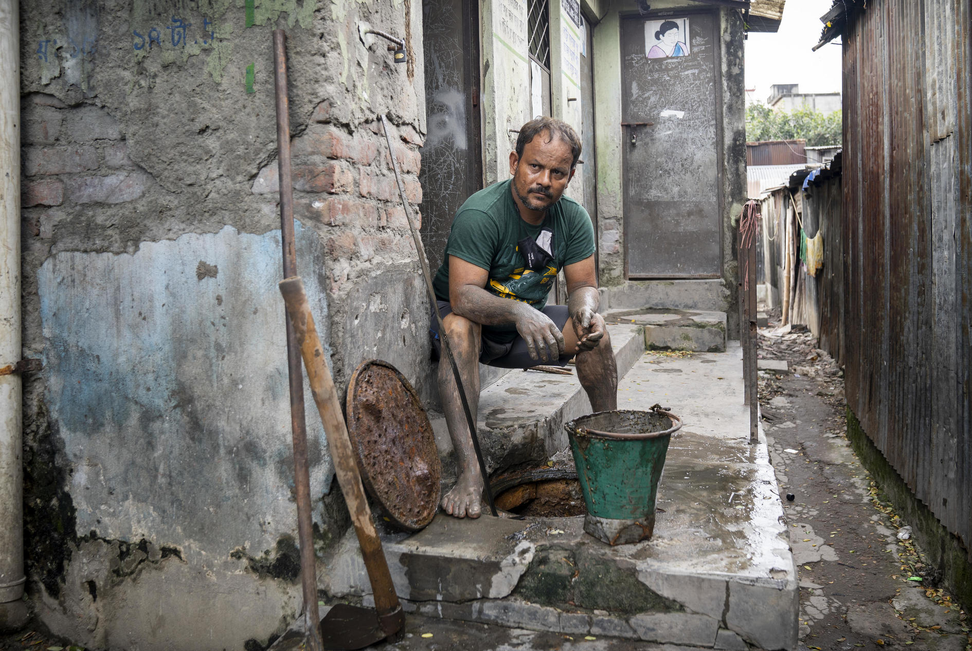 Mohammad Delowar Hossain, 44, a self-employed septic tank cleaner, works at a local community toilet without any safety gear. Image: WaterAid/ DRIK/Habibul Haque